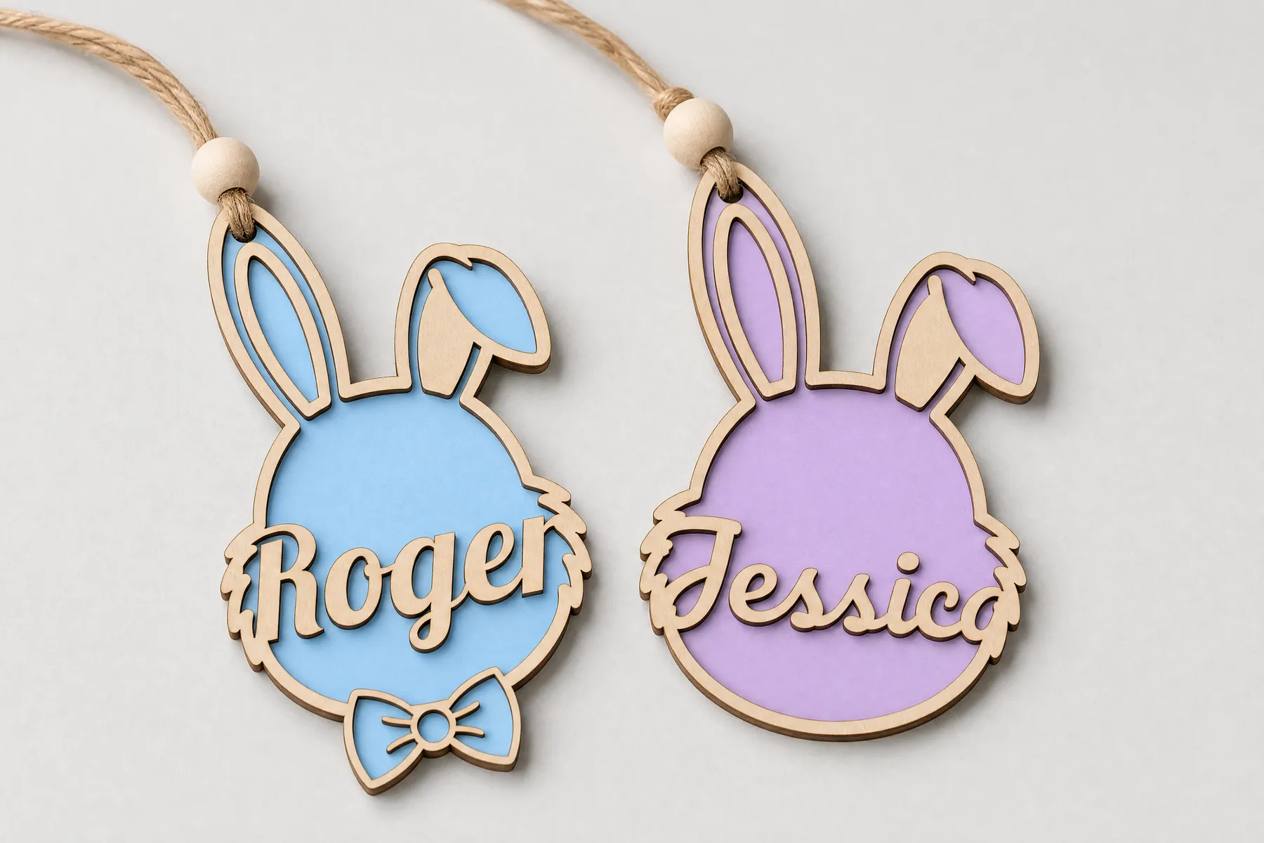 Two-layer Easter bunny name tags in wood and pastel acrylic, with names across the face, tied with twine